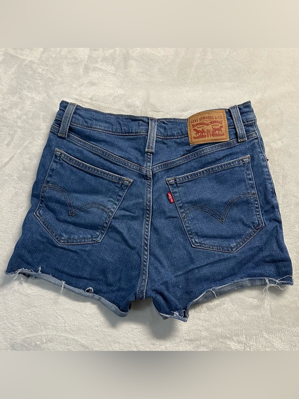 LEVI'S women's blue distressed raw hem high waisted shorts, 28".